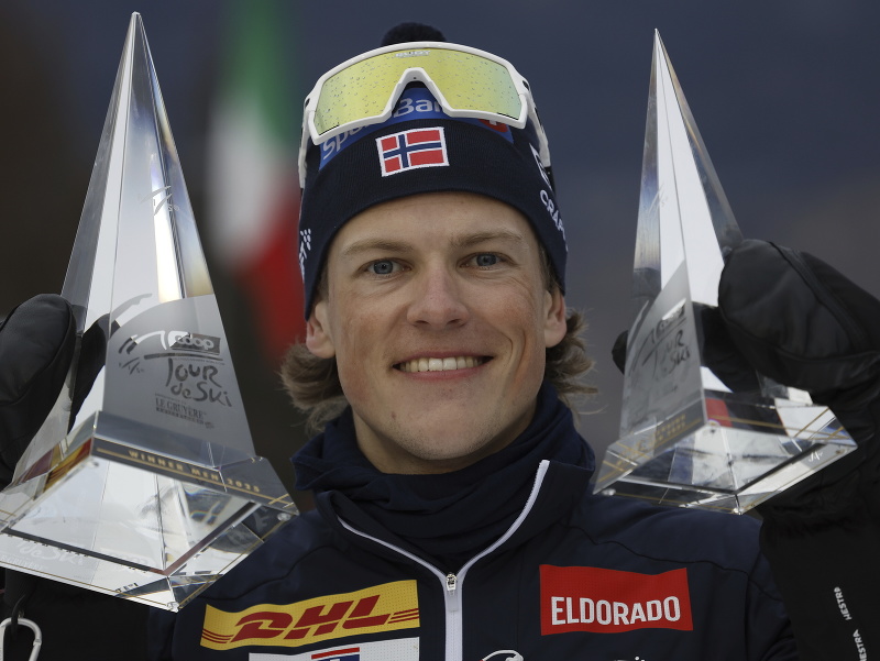 Nórsky bežec na lyžiach Johannes Hösflot Kläbo oslavuje na pódiu s trofejami po tom, ako sa stal víťazom 19. ročníka Tour de Ski 
