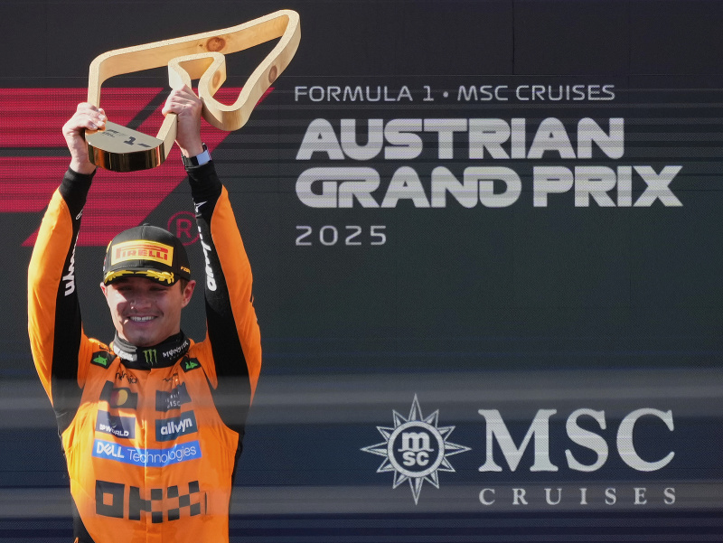 Britský pretekár F1 Lando Norris (vľavo) z tímu McLaren s víťaznou trofejou oslavuje triumf na Veľkej cene Rakúska F1