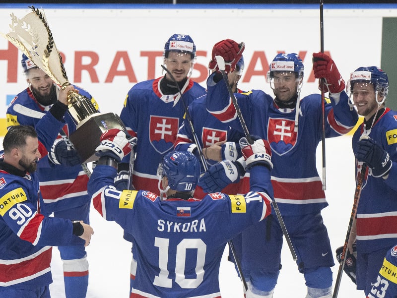 Slovenskí hokejoví reprezentanti s trofejou oslavujú postup na ZOH 2026