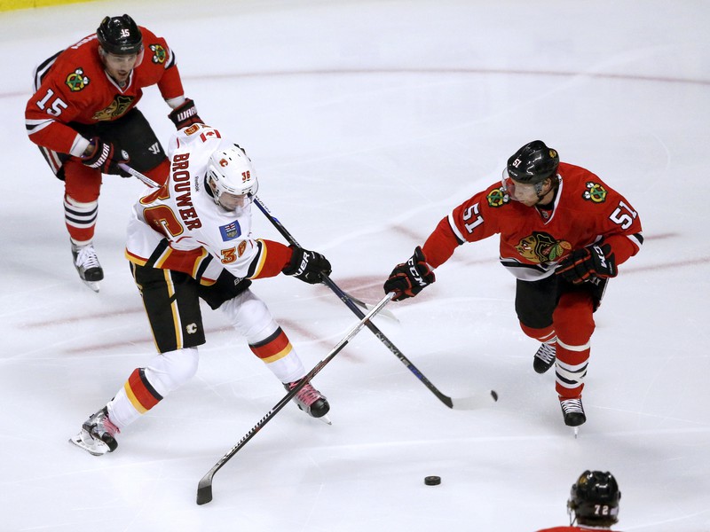 Troy Brouwer strieľa. Brian Campbell a Artem Anisimov bránia.