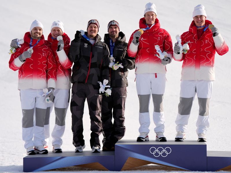 Zlatí švajčiarski lyžiari Franjo von Allmen (vpravo) a Tanguy Nef (druhý sprava) pózujú s dvomi striebornými tímami Švajčiarmi Loicom Meillardom (vľavo) a Marcom Odermattom (druhý zľava) a Rakúšanmi Manuelom Fellerom (tretí zľava) a Vincentom Kriechmayrom